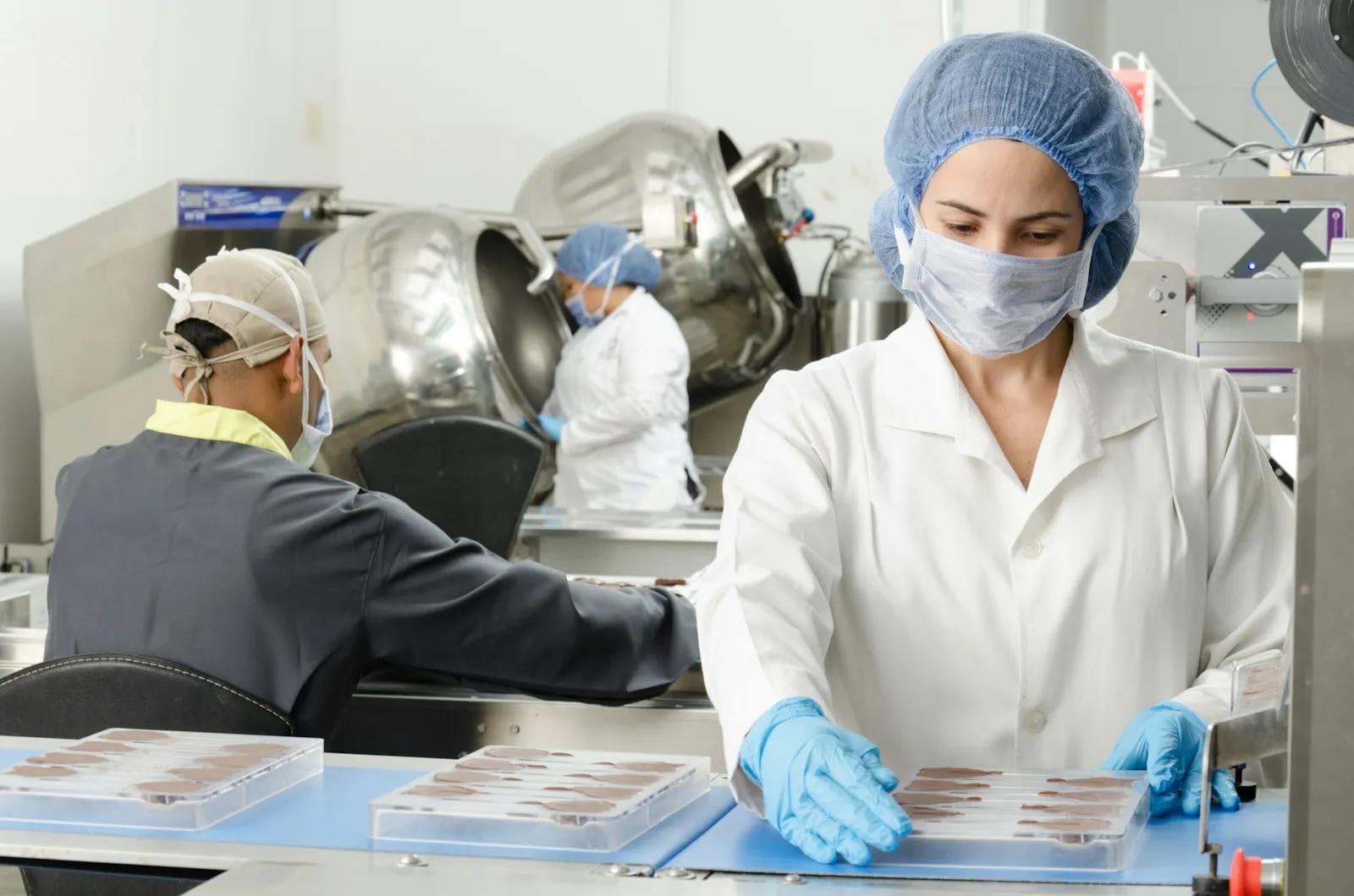 Technicians in cleanroom gowns working on production equipment