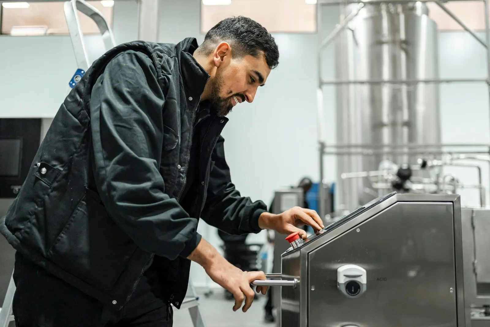A maintenance engineer working on a machine on a factory floor